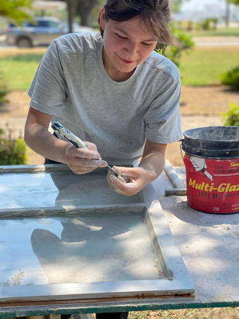 A young participant glazing a window